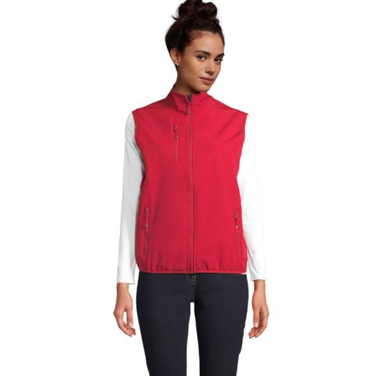 Bodywarmer softshell femme rouge piment porté, col montant, poche poitrine et poches latérales zippées