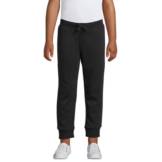 Jogging enfant personnalisé noir en molleton coupe slim porté avec un t-shirt blanc, chevilles en bord-côte