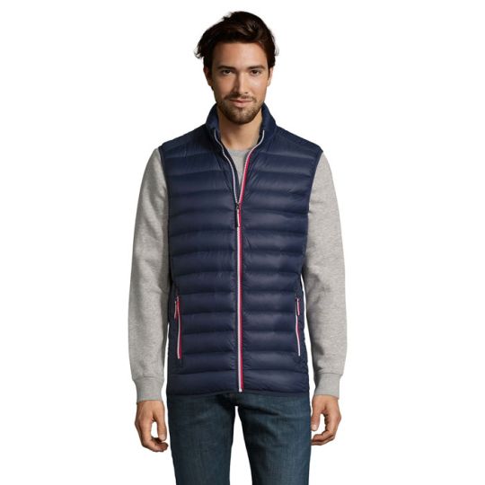 Doudoune sans manche personnalisée homme bleu marine portée sur un pull gris avec poches zippées à liseré rouge