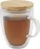 Tasse en verre double paroi personnalisée Leona remplie de thé ambré avec couvercle en bambou et anse en verre