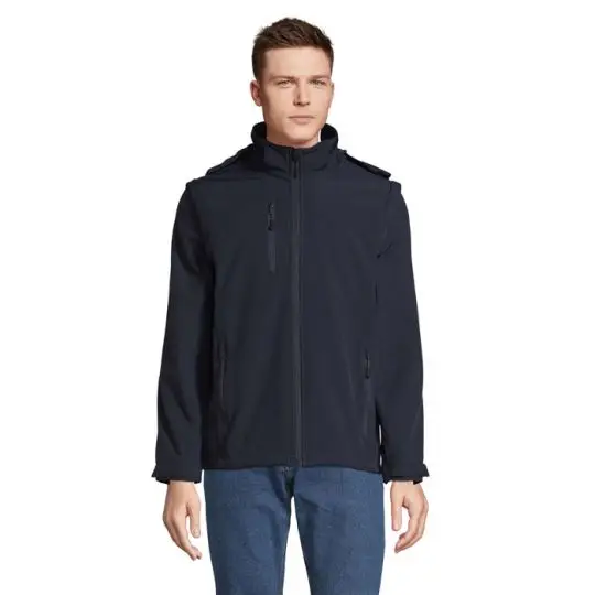 Veste softshell 3 en 1 personnalisée bleu abysse avec capuche, portée fermée par un homme avec un jean