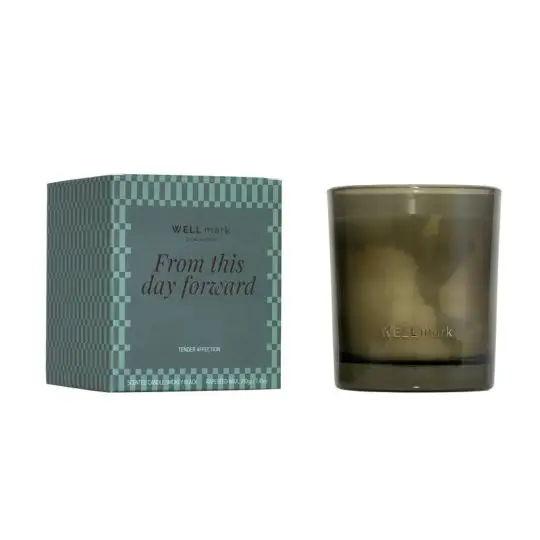 Bougie parfumée Tender Affection en verre vert fumé siglé Wellmark, à côté de son étui vert à motif géométrique
