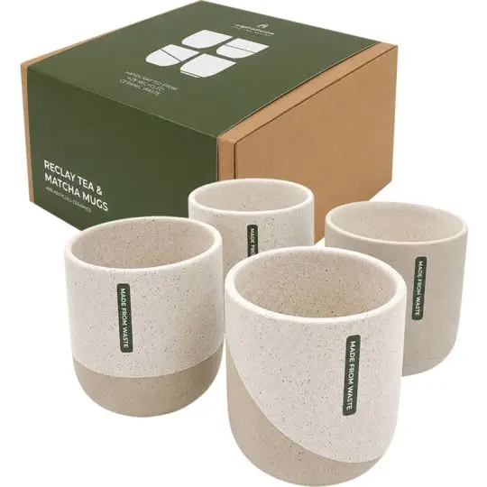 Lot de 4 tasses à thé ReClay en céramique recyclée crème mouchetée à base beige, devant leur boîte kraft et verte