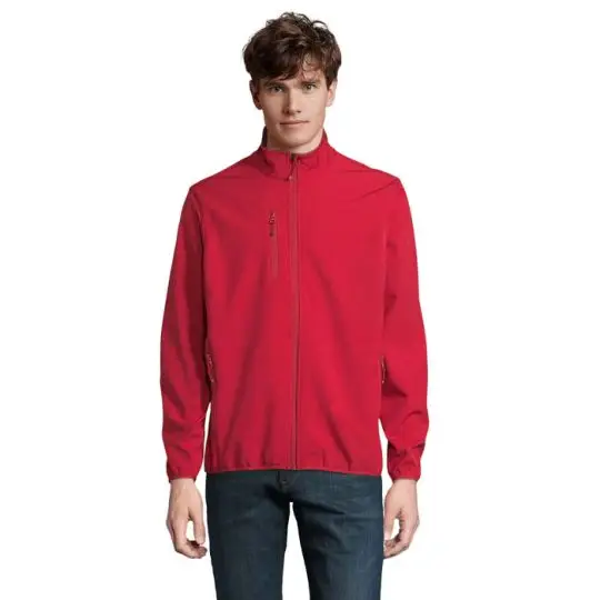 Veste softshell personnalisée rouge pour homme, zippée jusqu'au col montant, portée de face avec un jean