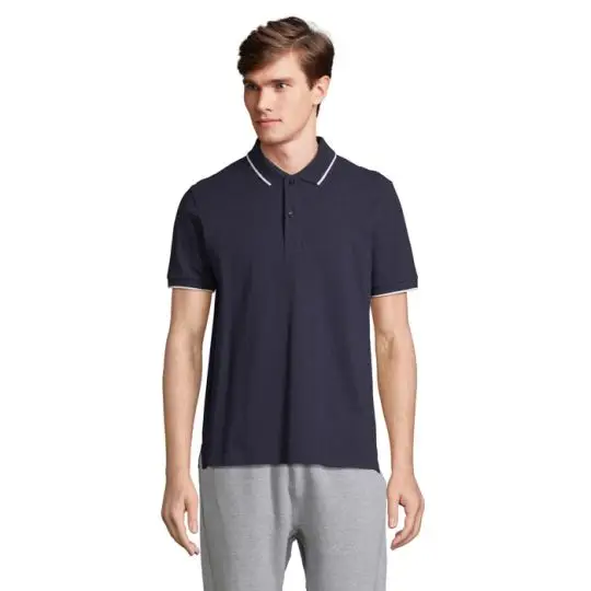 Polo bicolore marine à liseré blanc en coton peigné, patte deux boutons, porté avec un pantalon gris