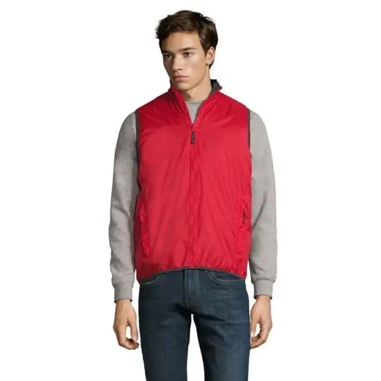 Homme portant un bodywarmer personnalisé rouge côté polyamide, zip ton sur ton et col montant sur un pull gris