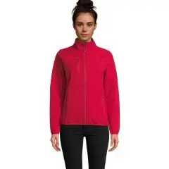 Veste softshell femme personnalisable rouge, col montant et zip central, portée avec un pantalon noir