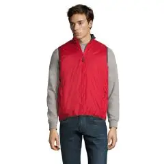 Homme portant un bodywarmer personnalisé rouge côté polyamide, zip ton sur ton et col montant sur un pull gris